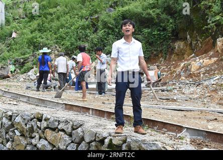 (160823) -- DAHUA, 23 août 2016 -- LAN Zhiping appelle les villageois à réparer une route dans le village de Nongxiong, comté autonome de Dahua Yao, région autonome de Guangxi Zhuang, sud de la Chine, 15 août 2016. Le village de Nongxiong, situé dans les zones montagneuses du Guangxi, compte 123 familles vivant sous le niveau de pauvreté parmi ses près de 2000 villageois. LAN Zhiping, 28 ans, a trouvé un moyen de sortir les villageois de la pauvreté grâce à l’élevage de poulets. Cette année, il a créé une coopérative d’élevage de volailles avec quatre autres villageois, dans laquelle plus de 2 300 poulets sont élevés. Une base hachurée qui env Banque D'Images