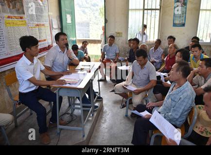 (160823) -- DAHUA, Aug. 23, 2016 -- Lan Zhiping (1st L) attends a villagers meeting in Nongxiong Village, Dahua Yao Autonomous County, south China s Guangxi Zhuang Autonomous Region, Aug. 17, 2016. Nongxiong Village, located in mountainous areas of Guangxi, has 123 families living under poverty standard among its nearly 2000 villagers. Lan Zhiping, 28 years old, has found out a way to lift villagers out of poverty through chicken raising industry. This year, he established a poultry raising cooperative with four other villagers, in which more than 2,300 chickens are raised. A hatching base whi Stock Photo