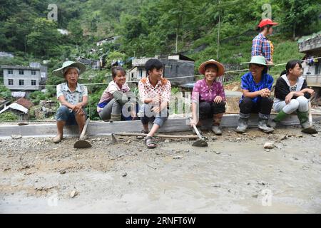 (160823) -- DAHUA, 23 août 2016 -- LAN Zhiping (3rd L) discute avec des villageois du village de Nongxiong, comté autonome de Dahua Yao, région autonome de Guangxi Zhuang, sud de la Chine, 15 août 2016. Le village de Nongxiong, situé dans les zones montagneuses du Guangxi, compte 123 familles vivant sous le niveau de pauvreté parmi ses près de 2000 villageois. LAN Zhiping, 28 ans, a trouvé un moyen de sortir les villageois de la pauvreté grâce à l’élevage de poulets. Cette année, il a créé une coopérative d’élevage de volailles avec quatre autres villageois, dans laquelle plus de 2 300 poulets sont élevés. Une base hachurée qui peut Banque D'Images