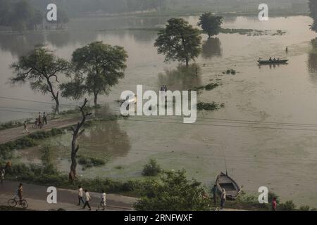 VARANASI, le 25 août 2016 -- les navetteurs parcourent une rue gorgée d'eau à Varanasi, dans le nord de l'État indien de l'Uttar Pradesh, le 25 août 2016. L'État est sous le choc des fortes pluies et des inondations depuis une semaine, avec de nombreuses rivières coulant au-dessus de la marque de danger. )(hy) INDIA-VARANASI-FLOOD TumpaxMondal PUBLICATIONxNOTxINxCHN Varanasi août 25 2016 navetteurs veau à travers une rue gorgée d'eau dans Varanasi État indien du nord de l'Uttar Pradesh août 25 2016 l'État a été sous de fortes pluies et inondations depuis la dernière semaine avec de NOMBREUSES rivières coulant au-dessus du danger Mark Hy Inde var Banque D'Images