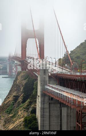 San Francisco, CA, USA - 12 juillet 2023 : Portrait, gros plan de la tour nord du Golden Gate Bridge à moitié cachée par un épais brouillard. Vue du nord au sud sur ro Banque D'Images