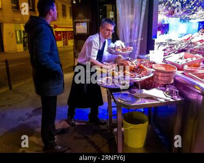 Paris, France, serveur travaillant à l'extérieur du restaurant traditionnel français Bistro, préparant la soirée Fish Tray, employés de restaurant Banque D'Images