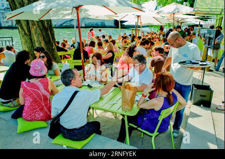 Paris, France, événements publics, grande foule de gens, touristes, partage de repas au restaurant Bistro français, à l'extérieur, sur le quai de Seine aux parasols de Paris plages Banque D'Images