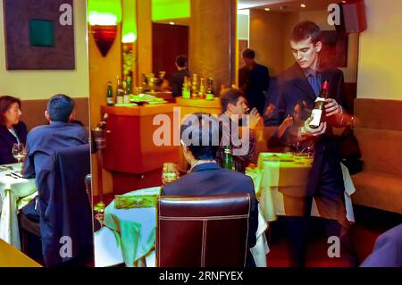 PARIS, France, - une foule nombreuse, assis aux tables à l'intérieur de la salle à manger, serveur français servant du vin dans le restaurant contemporain 'le Chamarré Montmartre', Banque D'Images