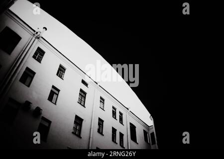 La photographie en noir et blanc représente de vieilles maisons et une entrée dans une cour à travers une arche. Nostalgie et intemporalité, mettant en valeur Histo Banque D'Images