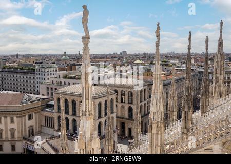 Milan, Italie, 6 août 2023 ; vue des bâtiments entourant le Duomo di Milano à travers les statues sur les flèches Banque D'Images