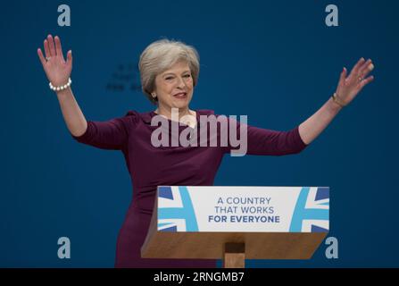 (161005) -- BIRMINGHAM, le 5 octobre 2016 -- la première ministre britannique Theresa May salue l'auditoire avant de prononcer un discours le 5 octobre 2016, le dernier jour de la conférence du Parti conservateur à Birmingham, en Grande-Bretagne. La première ministre britannique Theresa May a clôturé la conférence annuelle des conservateurs à Birmingham mercredi, affirmant que son parti occuperait le terrain central de la politique. GRANDE-BRETAGNE-BIRMINGHAM-PARTI CONSERVATEUR CONFÉRENCE-CONCLUSION HanxYan PUBLICATIONxNOTxINxCHN Birmingham OCT 5 2016 la première ministre britannique Theresa May salue le public avant de prononcer un discours LE dernier jour du contre Banque D'Images