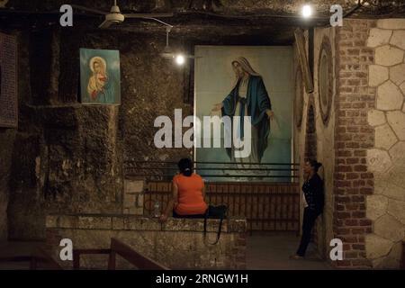 ASSIUT, le 11 octobre 2016 -- des femmes égyptiennes prient à l'église de la grotte à l'intérieur du couvent de la Vierge Marie, qui serait le dernier arrêt de la Sainte famille en haute-Égypte, dans la ville de Dronka d'Assiut, en Égypte, le 11 octobre 2016. Le monastère de la Vierge Marie à Al-Muharraq et le couvent de la Vierge Marie sur la montagne de la province d'Assiout dans le sud de l'Egypte se tiennent comme témoins oculaires historiques du voyage de fuite de la Sainte famille de Jésus-Christ, sa mère Vierge Marie et Saint Joseph en haute-Égypte il y a plus de 2 000 ans. ) Pour correspondre à la caractéristique de l'article : Vierge Marie s couvent, monastère à Assiut témoins oculaires de Saint Banque D'Images