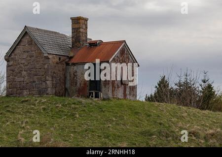 Vieux bergers hutte sur une colline avec un hangar en étain attaché Banque D'Images
