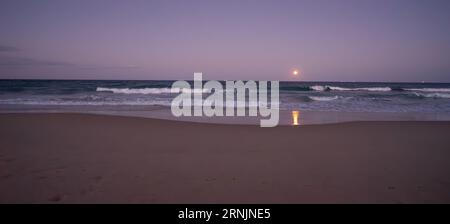 Une lune bleue, pleine lune, se levant au-dessus de l'océan Pacifique, Sunshine Coast, Australie orientale à la fin du mois d'août 2023, avec des navires à l'horizon et sur Banque D'Images