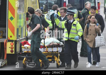 Bilder des Tages (170322) -- LONDRES, le 22 mars 2017 -- le personnel des services d'urgence transfère une personne blessée à l'extérieur des chambres du Parlement à Londres, en Grande-Bretagne, le 22 mars 2017. Mercredi, la police britannique a tiré sur un agresseur présumé devant les chambres du Parlement à Londres après qu'un officier ait été poignardé lors d'un incident terroriste décrit par la police. Le bâtiment a été bouclé immédiatement. Un véhicule a heurté plusieurs personnes sur le pont Westminster voisin.) BRITAIN-LONDON-ATTACK TimxIreland PUBLICATIONxNOTxINxCHN Images la journée Londres 22 2017 mars Service D'URGENCE transfert du personnel à Inj Banque D'Images