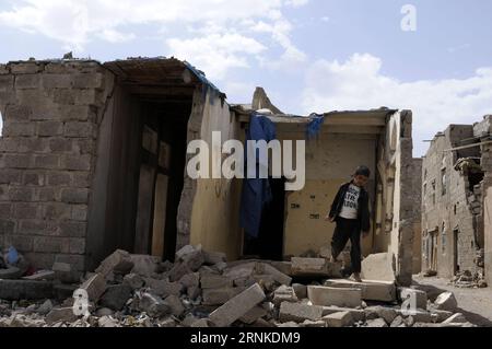 (170325) -- SANAA, 25 mars 2017 -- Un garçon marche sur les décombres d'une maison détruite lors de frappes aériennes dans le quartier de l'aéroport de Sanaa, capitale du Yémen, la veille du deuxième anniversaire de l'intervention militaire au Yémen, le 25 mars 2017. Alors que la guerre se poursuit au Yémen depuis deux ans depuis une intervention militaire dirigée par l’Arabie saoudite, les observateurs ont commencé à affirmer que l’objectif de l’intervention militaire est devenu flou, ce qui n’a pas encore abouti à une victoire militaire. Selon les médias citant le porte-parole de la coalition dirigée par l'Arabie saoudite, Ahmed Al-Asiri, la coalition a mené 90 000 frappes aériennes Banque D'Images