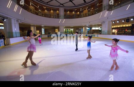 (170330) -- KUNMING, 30 mars 2017 -- l'entraîneur GE Qian (L) enseigne le patinage artistique aux enfants dans la patinoire Century Star Rink à Kunming, capitale de la province du Yunnan du sud-ouest de la Chine, le 9 mars 2017. Promouvoir 300 millions de personnes qui assistent aux sports d'hiver est une grande étape du programme national chinois de conditionnement physique. La province du Yunnan du sud-ouest de la Chine intègre les sports d hiver, le programme public de remise en forme et l écotourisme et encourage les entrepreneurs sociaux à investir dans les patinoires et les stations de ski. À l'heure actuelle, le Yunnan possède 3 patinoires et 3 autres sont en construction. Yunnan s Qujing prévoit de construire un centre de formation de Wint Banque D'Images