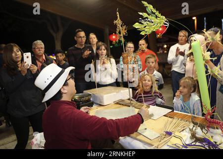 (170402) -- BOCA RATON, 2 avril 2017 -- Li Jun, un artisan chinois de dessin de sucre, remet un dessin de sucre à un enfant lors d'un festival de lanternes qui s'est tenu au Sunset Cove Amphitheater à Boca Raton, Floride, États-Unis, le 24 mars 2017. Le dessin du sucre, un art folklorique chinois traditionnel utilisant du caramel chaud pour créer des figures en deux dimensions, est parmi de nombreuses compétences folkloriques exposées du 24 février au 9 avril au Festival des lanternes chinoises dans le comté de Palm Beach, un paradis pour les vacanciers dans le sud de la Floride. (zy) US-BOCA RATON-CHINESE FOLK ARTS WangxYing PUBLICATIONxNOTxINxCHN Boca Raton avril 2 2017 lef Banque D'Images