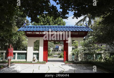 (170402) -- PALM BEACH, le 2 avril 2017 -- Un touriste passe devant la porte du jardin chinois de la Société des quatre Arts de Palm Beach, sur l'île de Palm Beach, aux États-Unis, le 24 mars 2017. Depuis leur construction en 1938, les jardins botaniques conçus par Mme Lorenzo Woodhouse ont servi de guide aux nouveaux propriétaires qui cherchent l’inspiration pour aménager leurs propres maisons. À seulement cinq minutes en voiture, au Norton Museum of Art à West Palm Beach, une exposition chinoise permanente impressionne également ses visiteurs. (zy) U.S.-PALM BEACH-CHINESE CULTURE WangxYing PUBLICATIONxNOTxINxCHN Palm Banque D'Images