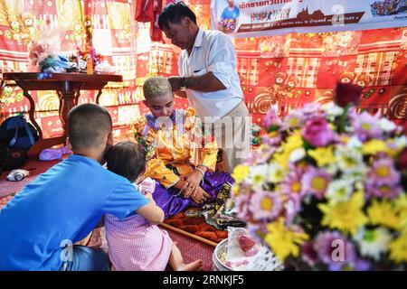 (170405) -- MAE HONG SON, 5 avril 2017 -- Phum (2e R), dix ans, s'habille avec l'aide de son père (1e R) pour les rituels d'ordination des moines novices POI sang long dans le nord de la Thaïlande, Mae Hong son, 2 avril 2017. Considéré comme l'un des plus grands moments de la vie d'un garçon, les rituels d'ordination des moines novices POI sang long sont organisés chaque année par les peuples Shan, également connus sous le nom de Tai Yai, qui résident principalement au Myanmar et dans le nord de la Thaïlande. Âgés entre 7 et 14 ans, les garçons, appelés sang long en langue shan, subiront une série de procédures rituelles au cours d’un POI sang Lo typique Banque D'Images