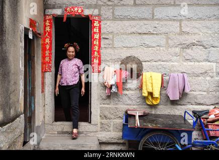 (170410) -- QUANZHOU, le 10 avril 2017 -- Une femme Xunpu est vue dans le village de Xunpu de la ville de Quanzhou, dans la province du Fujian du sud-est de la Chine, le 9 avril 2017. Les femmes Xunpu, qui portent des coiffures fleuries, des vêtements chinois traditionnels et des sabots en bois, sont des symboles des femmes chinoises laborieuses à Quanzhou, une ville portuaire connue comme le point de départ de l'ancienne route maritime de la soie. (lfj) CHINA-FUJIAN-QUANZHOU- XUNPU WOMEN (CN) ShenxHong PUBLICATIONxNOTxINxCHN Quanzhou avril 10 2017 une femme Xunpu SE TROUVE dans les lacs du village de Xunpu de la ville de Quanzhou Sud-est de la Chine S province du Fujian avril 9 2017 Xunpu Banque D'Images