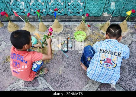 (170412) -- BANGKOK, 12 avril 2017 -- deux enfants utilisent le sable pour construire des stupas bouddhistes miniatures dans la perspective de Songkran au Wat Pho à Bangkok, Thaïlande, le 12 avril 2017. En plus des éclaboussures d'eau, les gens visitent également des temples et rendent hommage à Bouddha comme un moyen de célébrer le prochain Songkran, le nouvel an thaïlandais traditionnel qui tombe le 13 avril de chaque année.) (wtc) THAÏLANDE-BANGKOK-WAT PHO-SONGKRAN-BUDDHA-TRIBUTE LixMangmang PUBLICATIONxNOTxINxCHN 170412 Bangkok avril 12 2017 deux enfants utilisent du sable pour CONSTRUIRE des stupas bouddhistes miniatures dans la course au nouvel an thaïlandais AU Wat Pho à Bangkok T. Banque D'Images