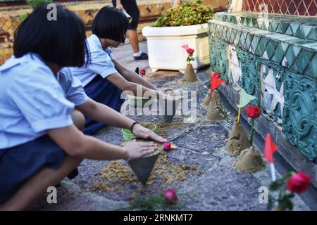 (170412) -- BANGKOK, 12 avril 2017 -- deux étudiants utilisent du sable pour construire des stupas bouddhistes miniatures dans la perspective de Songkran au Wat Pho à Bangkok, Thaïlande, le 12 avril 2017. En plus des éclaboussures d'eau, les gens visitent également des temples et rendent hommage à Bouddha comme un moyen de célébrer le prochain Songkran, le nouvel an thaïlandais traditionnel qui tombe le 13 avril de chaque année.) (wtc) THAÏLANDE-BANGKOK-WAT PHO-SONGKRAN-BUDDHA-TRIBUTE LixMangmang PUBLICATIONxNOTxINxCHN 170412 Bangkok avril 12 2017 deux étudiants utilisent du sable pour CONSTRUIRE des stupas bouddhistes miniatures dans la course au nouvel an thaïlandais AU Wat Pho à Bangkok T. Banque D'Images