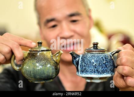 (170416) -- TAIPEI, 16 avril 2017 -- le céramiste Chen Chin Wang compare deux pots dans son atelier de Taichung, dans le centre de Taiwan, dans le sud-est de la Chine, le 16 avril 2017. Chen Chin Wang, qui travaille dans le secteur de la poterie depuis deux décennies, utilise de l’argile rouge locale ces dernières années et développe des céramiques avec son style particulier. )(wjq) CHINA-TAIWAN-TAICHUNG-RED CLAY POTERIES (CN) LiuxJunxi PUBLICATIONxNOTxINxCHN Taipei avril 16 2017 céramiste Chen Chin Wang compare Two Pot À son atelier à Taichung du centre de TAIWAN Sud-est de la Chine avril 16 2017 Chen Chin Wang qui a été dans le secteur de la poterie f Banque D'Images