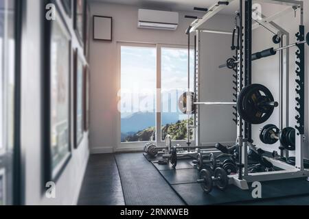 Salle d'haltérophilie personnelle confortable avec de belles fenêtres sur les collines de montagne vue sur la nature Banque D'Images