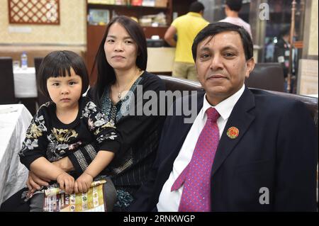 (170421) -- YIWU, 21 avril 2017 -- Syed Ummar Ali Bukhari (à droite), avec son épouse Hu Huaping et sa fille Aliyah posent pour une photo dans la ville de Yiwu, province du Zhejiang dans l'est de la Chine, le 18 avril 2017. Célèbre comme le supermarché du monde , Yiwu reçoit plus de 400 000 visiteurs d'outre-mer chaque année. Quelque 15 000 000 personnes de plus de 100 pays et régions vivent ici. Afin de résoudre les différends commerciaux étrangers, Yiwu a fondé un comité de médiation en 2013 pour aider à résoudre les différends impliquant des étrangers. Jusqu'à présent, 22 médiateurs de 20 pays ont rejoint le comité de médiation, y compris Bukhari du Pakistan. Bukhari regis Banque D'Images