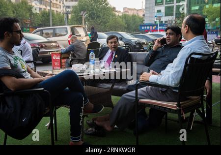 (170421) -- YIWU, 21 avril 2017 -- Syed Ummar Ali Bukhari (3rd R) parle avec ses amis dans la ville de Yiwu, province de Zhejiang dans l'est de la Chine, 18 avril 2017. Célèbre comme le supermarché du monde , Yiwu reçoit plus de 400 000 visiteurs d'outre-mer chaque année. Quelque 15 000 000 personnes de plus de 100 pays et régions vivent ici. Afin de résoudre les différends commerciaux étrangers, Yiwu a fondé un comité de médiation en 2013 pour aider à résoudre les différends impliquant des étrangers. Jusqu'à présent, 22 médiateurs de 20 pays ont rejoint le comité de médiation, y compris Bukhari du Pakistan. Bukhari a enregistré sa société de commerce extérieur à Yiwu Banque D'Images