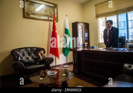 (170421) -- YIWU, 21 avril 2017 -- Syed Ummar Ali Bukhari (R) et sa fille Aliyah séjournent à son bureau dans la ville de Yiwu, province de Zhejiang dans l'est de la Chine, le 18 avril 2017. Célèbre comme le supermarché du monde , Yiwu reçoit plus de 400 000 visiteurs d'outre-mer chaque année. Quelque 15 000 000 personnes de plus de 100 pays et régions vivent ici. Afin de résoudre les différends commerciaux étrangers, Yiwu a fondé un comité de médiation en 2013 pour aider à résoudre les différends impliquant des étrangers. Jusqu'à présent, 22 médiateurs de 20 pays ont rejoint le comité de médiation, y compris Bukhari du Pakistan. Bukhari a enregistré son commerce extérieur Banque D'Images