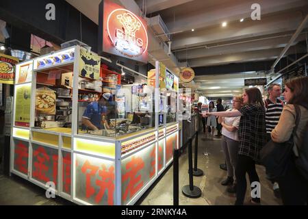 (170425) -- NEW YORK, 25 avril 2017 -- les clients choisissent leur Jianbing préféré au kiosque de M. Bing dans l'aire de restauration UrbanSpace à New York, aux États-Unis, le 17 avril 2017. UrbanSpace à Midtown New York est un endroit où les cols blancs viennent déjeuner pendant leurs journées de travail. Depuis quelques mois, les clients font toujours la queue devant un kiosque sous une bannière avec des caractères chinois. Ce que ce kiosque vend est une nourriture chinoise très authentique dans le nord de la Chine -- Jianbing, ou la crêpe chinoise. Le kiosque porte la marque MR. Bing et appartient à Brian Goldberg, qui est né et a grandi à New York. Goldberg Banque D'Images