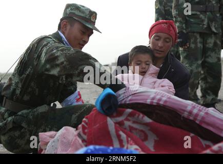 (170511) -- TAXKORGAN, le 11 mai 2017 -- Un soldat effectue un examen médical pour des enfants dans l'établissement temporaire du village de Kuzigun, dans le comté de Taxkorgan, dans la région autonome ouïgour du Xinjiang, au nord-ouest de la Chine, le 11 mai 2017. Huit personnes ont été confirmées mortes et 11 autres ont été blessées après un tremblement de terre de magnitude 5,5 qui a secoué le comté de Taxkorgan jeudi à 5:58 heures (mercredi à 2158 heures GMT). (Yxb) CHINA-XINJIANG-EARTHQUAKE(CN) LixJing PUBLICATIONxNOTxINxCHN 170511 Taxkorgan Mai 11 2017 un soldat fait un bilan médical pour les enfants À l'établissement temporaire de Village dans le comté de Taxkorgan Northwe Banque D'Images