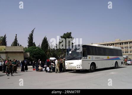 (170514) -- DAMAS, le 14 mai 2017 -- Une foule attend près d'un bus pour des évacuations du quartier de Qaboun à Damas, à Damas, capitale de la Syrie, le 14 mai 2017. Un total de 2 289 personnes, dont 1 058 rebelles, ont évacué dimanche le quartier de Qaboun, à l'est de la capitale Damas, un jour après que l'armée eut pris le contrôle du quartier clé, a rapporté la télévision d'État. (zf) SYRIE-DAMAS-FAMILLES-REBELLES-ÉVACUATION-DU-QUARTIER DE QABOUN AmmarxSafarjalani PUBLICATIONxNOTxINxCHN 170514 DAMAS 14 2017 mai Une foule de célébrités attend près D'Un bus pour venir de la Neigh orientale Banque D'Images