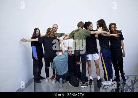 (170515) -- VENISE, 15 mai 2017 -- des artistes se produisent au pavillon de l'Allemagne lors de la 57e Biennale d'art à Venise, Italie, le 13 mai 2017. La chorégraphe allemande Anne Imhof a reçu le Lion d’or de la meilleure participation nationale à la 57e Biennale d’Art de Venise. Pour sa pièce intitulée Faust d'après le conte allemand classique d'un homme qui vend son âme au diable en échange d'une connaissance et d'un pouvoir illimités, Imhof a rempli le pavillon blanc et rectangulaire de l'Allemagne avec des murs et des planchers de verre qui se croisent, et puis placé un groupe d'artistes au sous-sol. Les visiteurs observent les artistes Banque D'Images