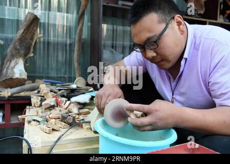 (170518) -- ZHENGZHOU, 18 mai 2017 -- le villageois Shen Yuxiao fabrique un artisanat pour les touristes dans le village de Guoliang à Huixian, province du Henan, au centre de la Chine, le 18 mai 2017. Le couloir de la falaise de Guoliang est une route de 1 250 mètres de long construite le long de la falaise. La construction de cette route miraculeuse a duré cinq ans, de 1972 à 1977, et a été construite purement à la main par les villageois du village de Guoliang. Grâce à cette route, les villageois ici rejettent la pauvreté. ) (lfj) CHINA-HENAN-GOULIANG VILLAGE-FALAISE ROAD (CN) ZhuxXiang PUBLICATIONxNOTxINxCHN Zhengzhou Mai 18 2017 village Shen Yuxiao fait un artisanat pour la tournée Banque D'Images