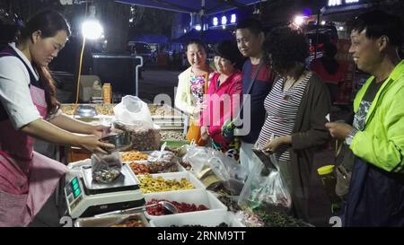 (170518) -- ZHENGZHOU, 18 mai 2017 -- les touristes achètent des collations locales dans un marché nocturne dans le village de Guoliang, à Huixian, province du Henan en Chine centrale, le 16 mai 2017. Le couloir de la falaise de Guoliang est une route de 1 250 mètres de long construite le long de la falaise. La construction de cette route miraculeuse a duré cinq ans, de 1972 à 1977, et a été construite purement à la main par les villageois du village de Guoliang. Grâce à cette route, les villageois ici rejettent la pauvreté. ) (lfj) CHINA-HENAN-GOUOLIANG VILLAGE-FALAISE ROAD (CN) ZhangxFengguo PUBLICATIONxNOTxINxCHN Zhengzhou Mai 18 2017 touristes achètent des collations locales À un marché nocturne Banque D'Images