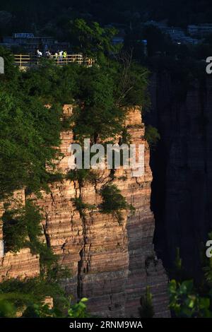 (170518) -- ZHENGZHOU, 18 mai 2017 -- les touristes apprécient le paysage sur une plate-forme dans le village de Guoliang, Huixian, province du Henan en Chine centrale, le 17 mai 2017. Le couloir de la falaise de Guoliang est une route de 1 250 mètres de long construite le long de la falaise. La construction de cette route miraculeuse a duré cinq ans, de 1972 à 1977, et a été construite purement à la main par les villageois du village de Guoliang. Grâce à cette route, les villageois ici rejettent la pauvreté. ) (lfj) CHINA-HENAN-GUOLIANG VILLAGE-FALAISE ROAD (CN) ZhuxXiang PUBLICATIONxNOTxINxCHN Zhengzhou Mai 18 2017 les touristes profitent du paysage À une plate-forme dans le village de Guoliang Banque D'Images