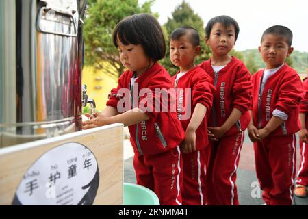 (170603) -- HUACHI, 3 juin 2017 -- des enfants font la queue pour se laver les mains dans un jardin d'enfants du village de Shangwan, dans le comté de Huachi, province du Gansu, au nord-ouest de la Chine, le 3 juin 2017. Pour améliorer l ' éducation à l ' hygiène dans les zones reculées, la China Develpment Research Foundation et Unilever ont mené un projet visant à promouvoir le lavage des mains chez les enfants en classe. À ce jour, le projet a couvert plus de 10 000 000 enfants ruraux dans plusieurs provinces de Chine. (Ry) CHINA-GANSU-HUACHI-RURAL KINDERGARTEN-EDUCATION (CN) ChenxBin PUBLICATIONxNOTxINxCHN Huachi juin 3 2017 les enfants font la queue pour se laver les mains À un K Banque D'Images