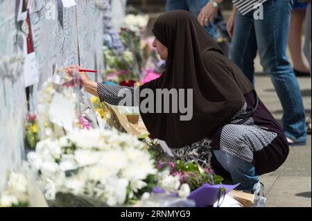 (170616) -- LONDRES, le 16 juin 2017 -- Une femme signe le mur des messages pour les victimes de Grenfell Tower à Londres, en Grande-Bretagne, le 16 juin 2017. La police métropolitaine de Londres a confirmé vendredi qu'au moins 30 personnes sont mortes dans l'incendie de cette semaine qui a balayé un immeuble résidentiel dans l'ouest de Londres. Bien que la police n'ait pas spéculé sur le nombre éventuel de décès, des sources communautaires locales affirment qu'au moins 70 personnes de la tour Grenfell sont toujours portées disparues, y compris des familles entières. BRITAIN-LONDON-GRENFELL TOWER-FIRE-AFTERMATH RayxTang PUBLICATIONxNOTxINxCHN 170616 Londres juin 16 2017 une femme signe Banque D'Images