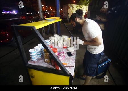 (170620) -- LE CAIRE, 20 juin 2017 -- un jeune homme égyptien prépare de la nourriture à un Bean Cart, un petit stand de nourriture de rue qui sert le repas traditionnel pré-jeûne, connu sous le nom de suhur, pendant le mois sacré musulman du Ramadan, sur le trottoir de la banlieue d'Héliopolis au Caire, en Égypte, le 19 juin 2017. Les charrettes à haricots uniques sont exploitées par un groupe de jeunes Égyptiens hautement instruits, qui espèrent utiliser une partie des revenus pour des activités caritatives. Le but principal de ce projet l'année dernière est la charité, a déclaré Hussein Hamza, un cofondateur de 30 ans du projet, à Xinhua. Le groupe ne travaille que pendant Ramada Banque D'Images