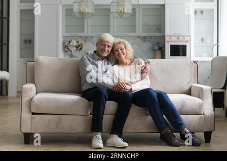 Heureux et attrayant couple retraité mûr serrant à la maison Banque D'Images