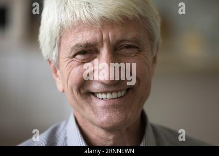 Vieil homme joyeux avec des rides et des cheveux gris en gros plan Banque D'Images