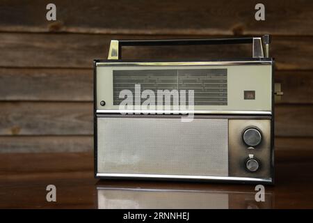 Récepteur radio vintage des années 1970 sur une table polie sur le fond en bois Banque D'Images