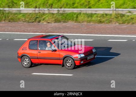 Années 1992 90 années 1990 Rouge PEUGEOT 205 3 portes supermini, GL 1,6 1580cc GTI ; voyageant à grande vitesse sur l'autoroute M6 dans le Grand Manchester, Royaume-Uni Banque D'Images