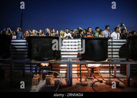 (170718) -- NAXOS, le 18 juillet 2017 -- les gens attendent d'avoir des frites de pommes de terre pendant l'événement sur l'île de Naxos, en Grèce, le 15 juillet 2017. Il a fallu plus de 1 500 kg de pommes de terre Naxos crues, 22 chaudrons énormes, le travail acharné de 40 bénévoles pour battre le record du monde Guinness pour la cuisson du lot de frites le plus lourd. La balance électronique qui pesait les pommes de terre frites indiquait 554 kg, soit 100 kg de plus que le précédent record du monde établi en 2014 à Eagles, Idaho, aux États-Unis. L'événement a eu lieu pendant le 8e Festival de la pomme de terre de Naxos, l'un des festivals gastronomiques les plus populaires de la mer Égée. )(zhf) Banque D'Images