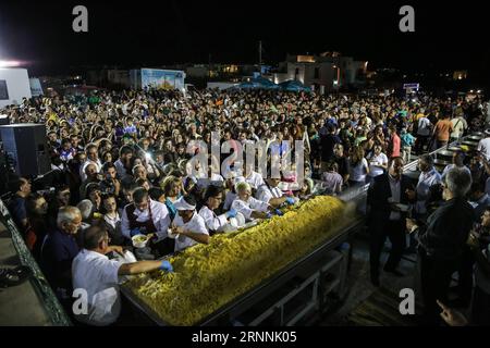 (170718) -- NAXOS, 18 juillet 2017 -- les gens font la queue pour avoir des frites de pommes de terre pendant l'événement sur l'île de Naxos, en Grèce, le 15 juillet 2017. Il a fallu plus de 1 500 kg de pommes de terre Naxos crues, 22 chaudrons énormes, le travail acharné de 40 bénévoles pour battre le record du monde Guinness pour la cuisson du lot de frites le plus lourd. La balance électronique qui pesait les pommes de terre frites indiquait 554 kg, soit 100 kg de plus que le précédent record du monde établi en 2014 à Eagles, Idaho, aux États-Unis. L'événement a eu lieu pendant le 8e Festival de la pomme de terre de Naxos, l'un des festivals gastronomiques les plus populaires de la mer Égée. )(zhf Banque D'Images