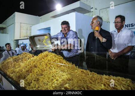 (170718) -- NAXOS, le 18 juillet 2017 -- Un homme verse des frites de pommes de terre lors de l'événement sur l'île de Naxos, en Grèce, le 15 juillet 2017. Il a fallu plus de 1 500 kg de pommes de terre Naxos crues, 22 chaudrons énormes, le travail acharné de 40 bénévoles pour battre le record du monde Guinness pour la cuisson du lot de frites le plus lourd. La balance électronique qui pesait les pommes de terre frites indiquait 554 kg, soit 100 kg de plus que le précédent record du monde établi en 2014 à Eagles, Idaho, aux États-Unis. L'événement a eu lieu pendant le 8e Festival de la pomme de terre de Naxos, l'un des festivals gastronomiques les plus populaires de la mer Égée. )(zhf) GRÈCE- Banque D'Images