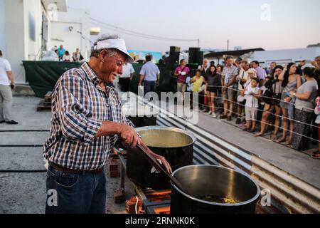 (170718) -- NAXOS, le 18 juillet 2017 -- Un homme cuisine des frites de pommes de terre lors de l'événement sur l'île de Naxos, en Grèce, le 15 juillet 2017. Il a fallu plus de 1 500 kg de pommes de terre Naxos crues, 22 chaudrons énormes, le travail acharné de 40 bénévoles pour battre le record du monde Guinness pour la cuisson du lot de frites le plus lourd. La balance électronique qui pesait les pommes de terre frites indiquait 554 kg, soit 100 kg de plus que le précédent record du monde établi en 2014 à Eagles, Idaho, aux États-Unis. L'événement a eu lieu pendant le 8e Festival de la pomme de terre de Naxos, l'un des festivals gastronomiques les plus populaires de la mer Égée. )(zhf) GRÈCE- Banque D'Images