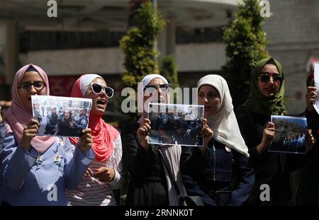 (170718) -- NAPLOUSE, 18 juillet 2017 -- des palestiniennes tiennent des photos de soldats israéliens attaquant des femmes dans la cour de la mosquée Al-Aqsa lors d'une manifestation contre la fermeture de l'enceinte de la mosquée Al-Aqsa à Jérusalem, dans la ville de Naplouse en Cisjordanie, le 18 juillet 2017. La mosquée Al-Aqsa a été fermée le 14 juillet après la mort de trois Palestiniens et de deux policiers israéliens dans une attaque armée. Israël a annoncé le 16 juillet la réouverture progressive de certaines des entrées de la mosquée Al-Aqsa, après avoir installé des portails électroniques, des caméras de surveillance et des équipements sensibles pour des raisons de sécurité Banque D'Images