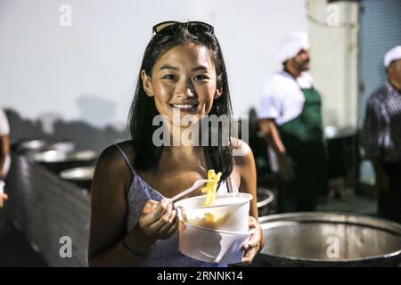 (170718) -- NAXOS, le 18 juillet 2017 -- Un touriste apprécie les frites de pommes de terre lors de l'événement Naxos Island, Grèce, le 15 juillet 2017. Il a fallu plus de 1 500 kg de pommes de terre Naxos crues, 22 chaudrons énormes, le travail acharné de 40 bénévoles pour battre le record du monde Guinness pour la cuisson du lot de frites le plus lourd. La balance électronique qui pesait les pommes de terre frites indiquait 554 kg, soit 100 kg de plus que le précédent record du monde établi en 2014 à Eagles, Idaho, aux États-Unis. L'événement a eu lieu pendant le 8e Festival de la pomme de terre de Naxos, l'un des festivals gastronomiques les plus populaires de la mer Égée. )(zhf) GREEC Banque D'Images