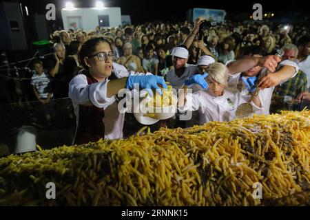 (170718) -- NAXOS, le 18 juillet 2017 -- des bénévoles servent des frites de pommes de terre lors de l'événement sur l'île de Naxos, en Grèce, le 15 juillet 2017. Il a fallu plus de 1 500 kg de pommes de terre Naxos crues, 22 chaudrons énormes, le travail acharné de 40 bénévoles pour battre le record du monde Guinness pour la cuisson du lot de frites le plus lourd. La balance électronique qui pesait les pommes de terre frites indiquait 554 kg, soit 100 kg de plus que le précédent record du monde établi en 2014 à Eagles, Idaho, aux États-Unis. L'événement a eu lieu pendant le 8e Festival de la pomme de terre de Naxos, l'un des festivals gastronomiques les plus populaires de la mer Égée. )(zhf) GR Banque D'Images