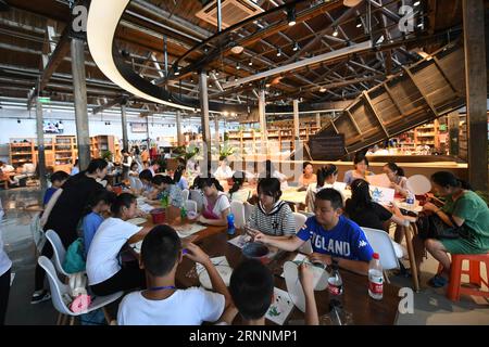 (170721) -- HANGZHOU, 21 juillet 2017 -- les enfants apprennent la peinture en éventail dans un hall d'exposition d'artisanat près du Grand Canal à Hangzhou, dans la province du Zhejiang de l'est de la Chine, le 20 juillet 2017. Une ceinture culturelle et pittoresque, comprenant des musées, des zones culturelles et créatives, des reliques historiques et des rues anciennes, s'est formée le long de la section de 12 kilomètres du Grand Canal Pékin-Hangzhou dans le district de Gongshu à Hangzhou. )(MCG)(zt) CHINA-HANGZHOU-GRAND CANAL (CN) HuangxZongzhi PUBLICATIONxNOTxINxCHN Hangzhou juillet 21 2017 les enfants apprennent la peinture de soutien dans une salle d'exposition d'artisanat près du Grand Canal en Banque D'Images